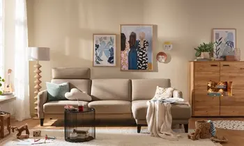 Sie sehen ein helles Sofa mit einem Highboard aus Massivholz 